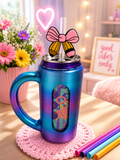 Pencil and pink bow straw topper on an iridescent blue-purple can holder mug in a cozy room setting