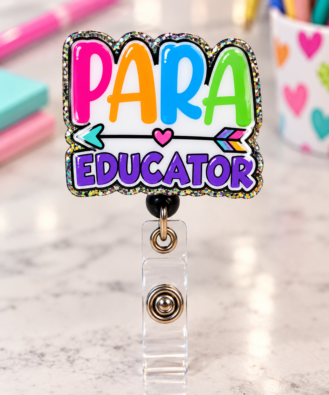 Close-up of multicolored PARA lettering and purple EDUCATOR text on a glitter-edged badge reel