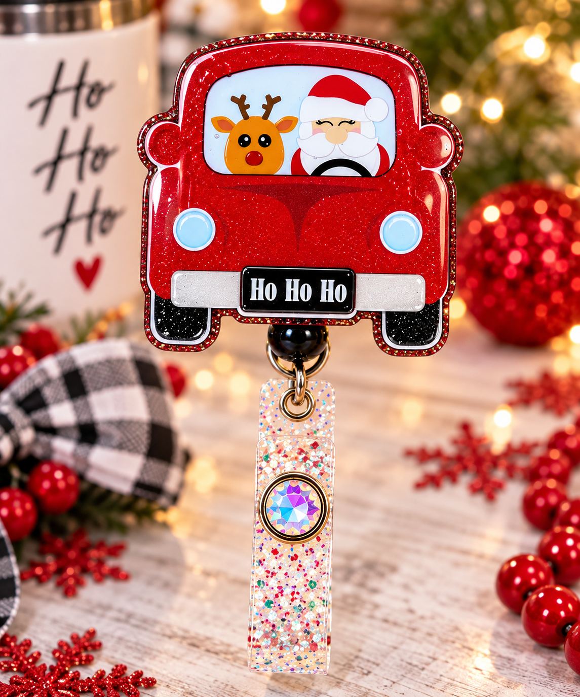 Close-up of Santa and reindeer glitter Christmas car badge reel with pale blue headlight artwork