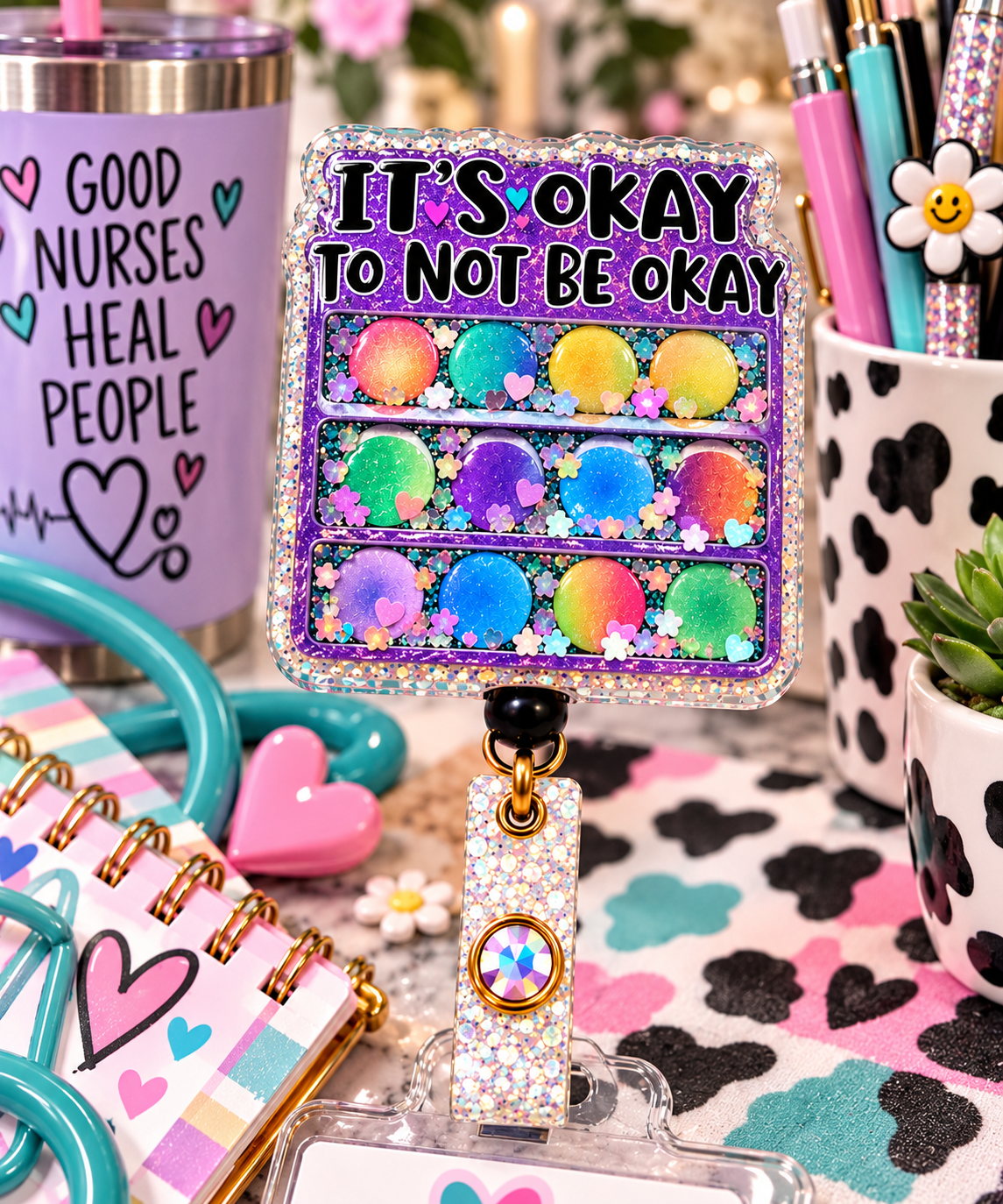 Encouraging rainbow circle badge reel with purple framing in a mental health themed flat lay