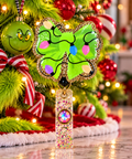 Green Christmas bow badge reel with colorful light artwork and gold glitter edging