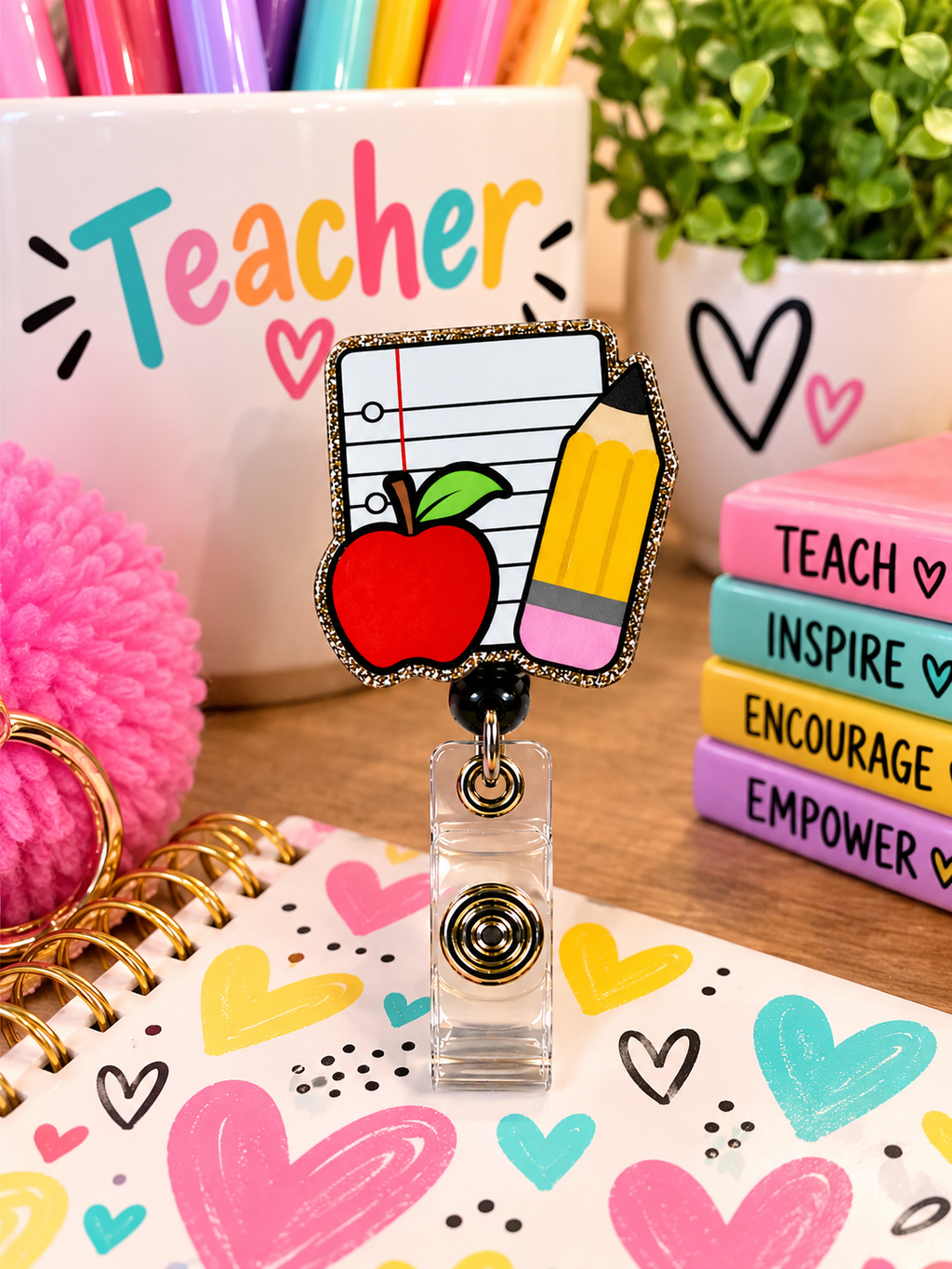 Teacher badge reel with clear snap strap displayed beside a teaching mug and colorful notebooks