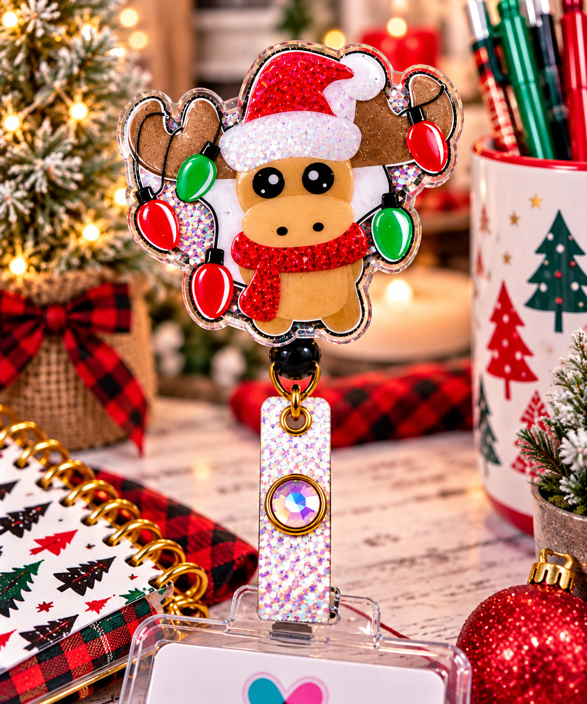 Christmas reindeer badge reel with glitter Santa hat, red scarf, and red and green light artwork